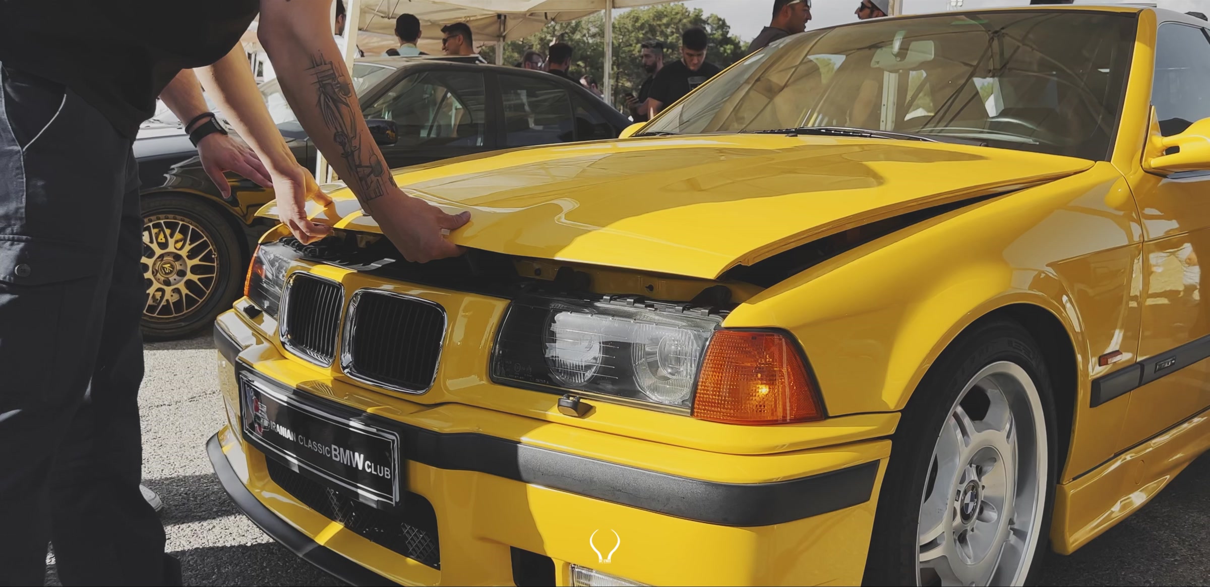 A yellow BMW E36 in a frame from the exhibition film